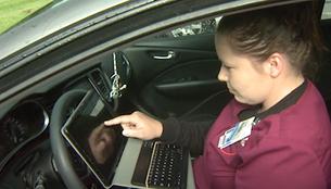 Woman in car using laptop